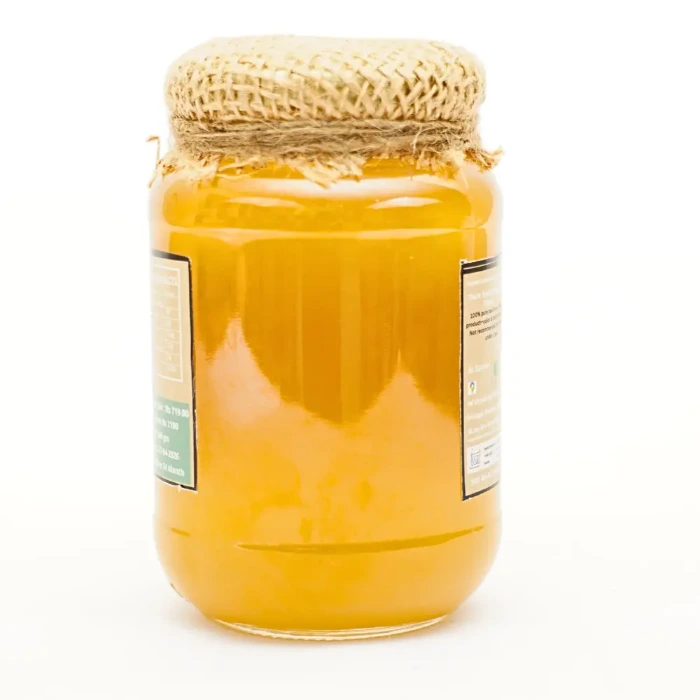 Jar of golden Kashmiri honey with jute cloth lid on white background, AL ZAREEN