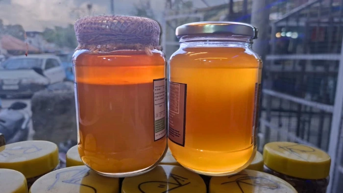 Two jars of amber honey side by side